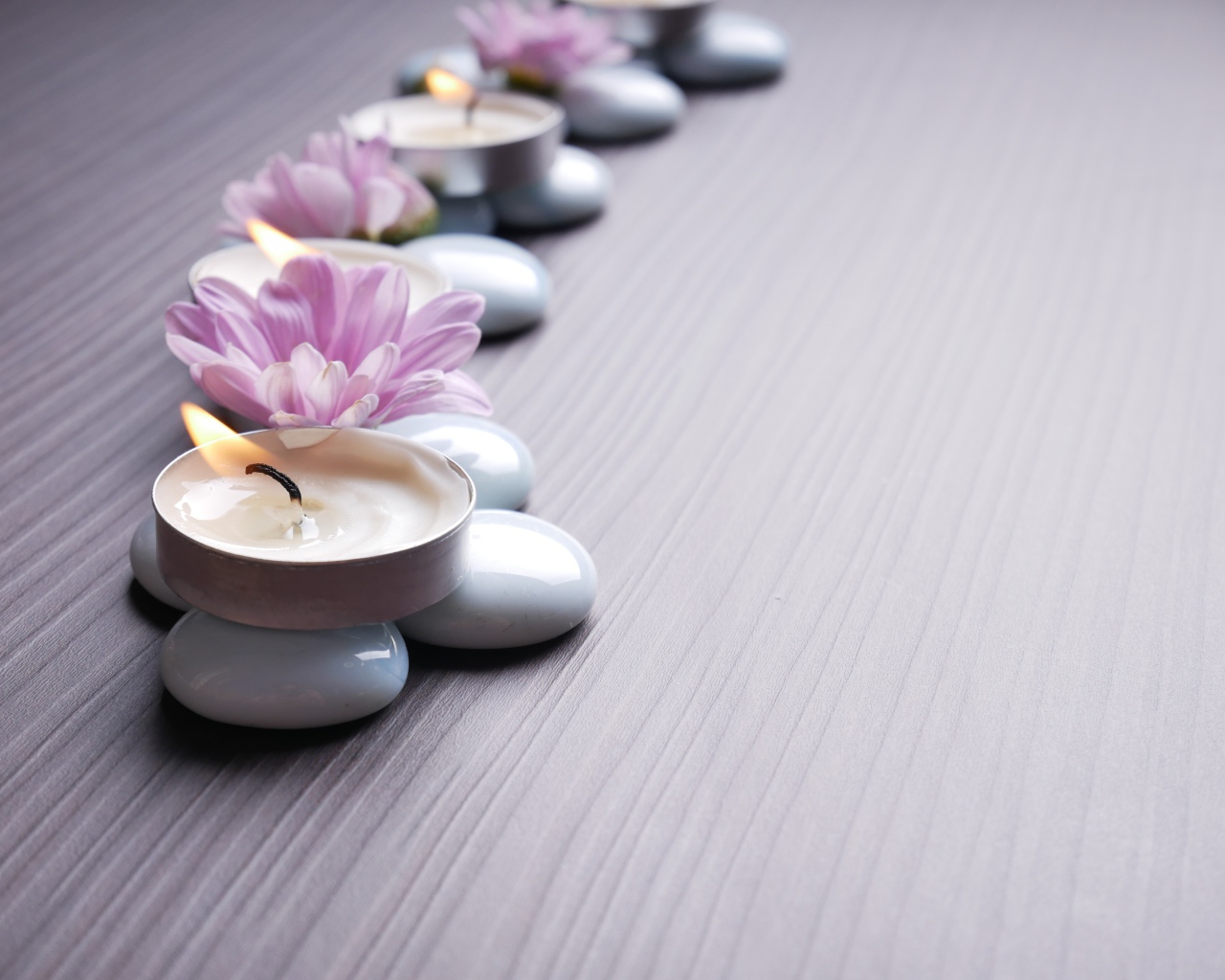 Камни с ароматическими свечами и цветами хризантемы