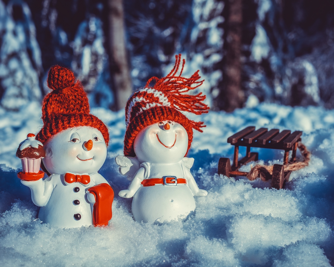 Две статуэтки снеговиков на снегу
