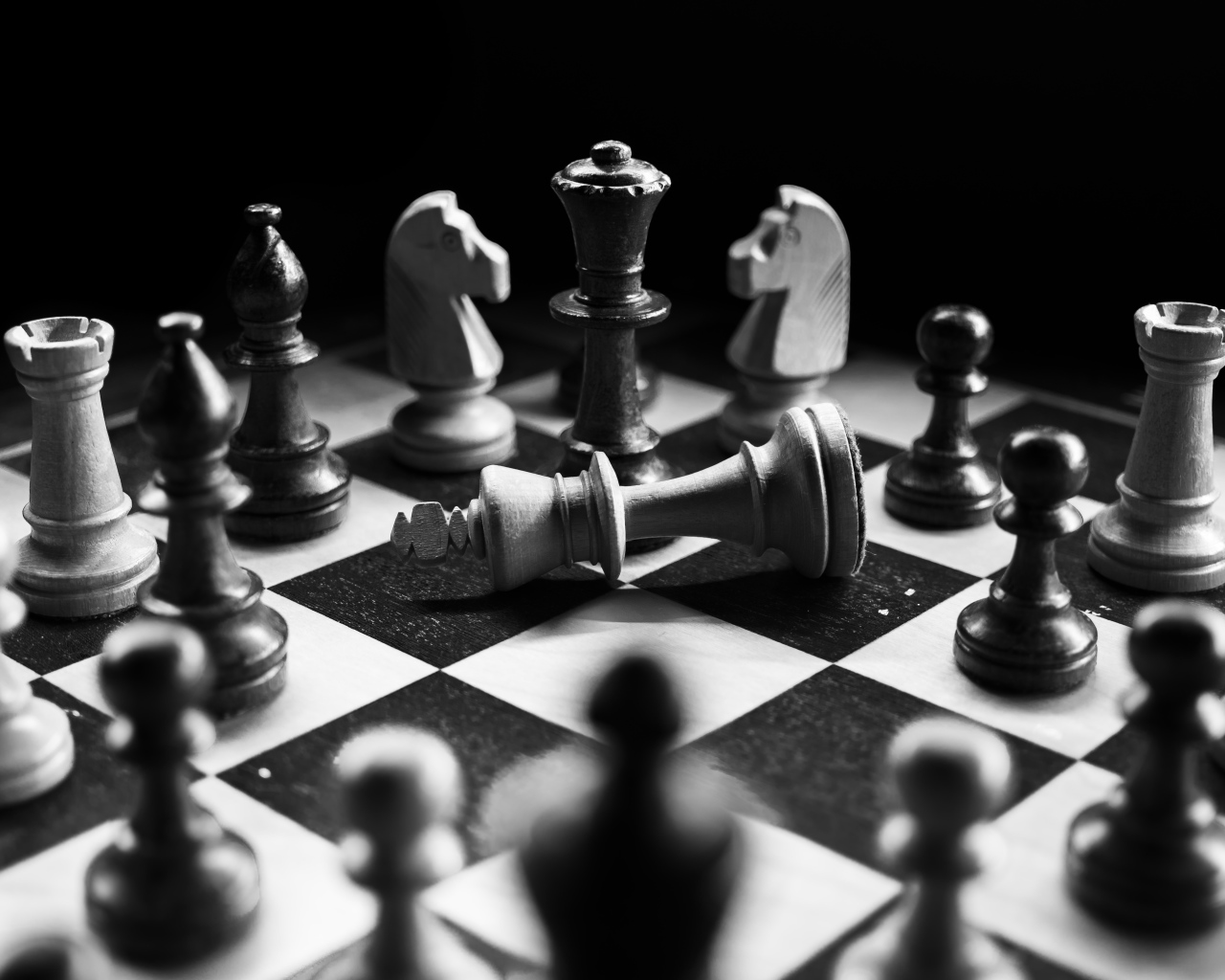 Деревянные шахматные фигуры на доске черно-белое фото