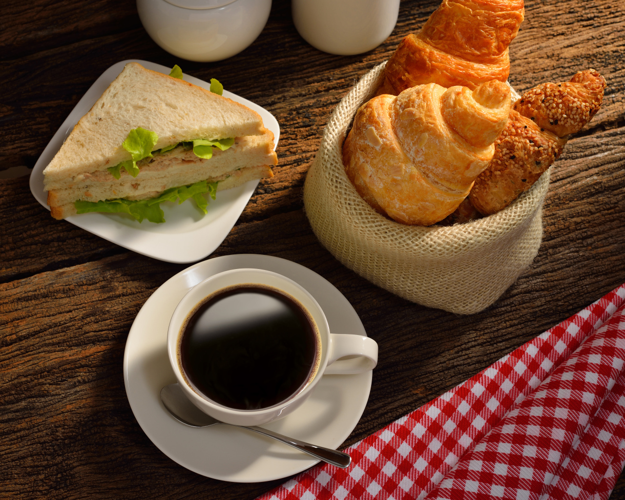 Чашка кофе с круассанами и сендвичем на завтрак