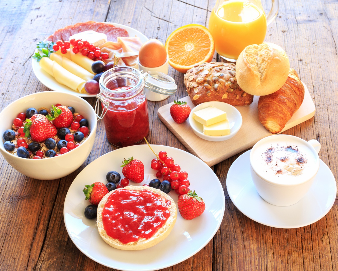 Аппетитный завтрак на столе с бутербродами, кофе и ягодами