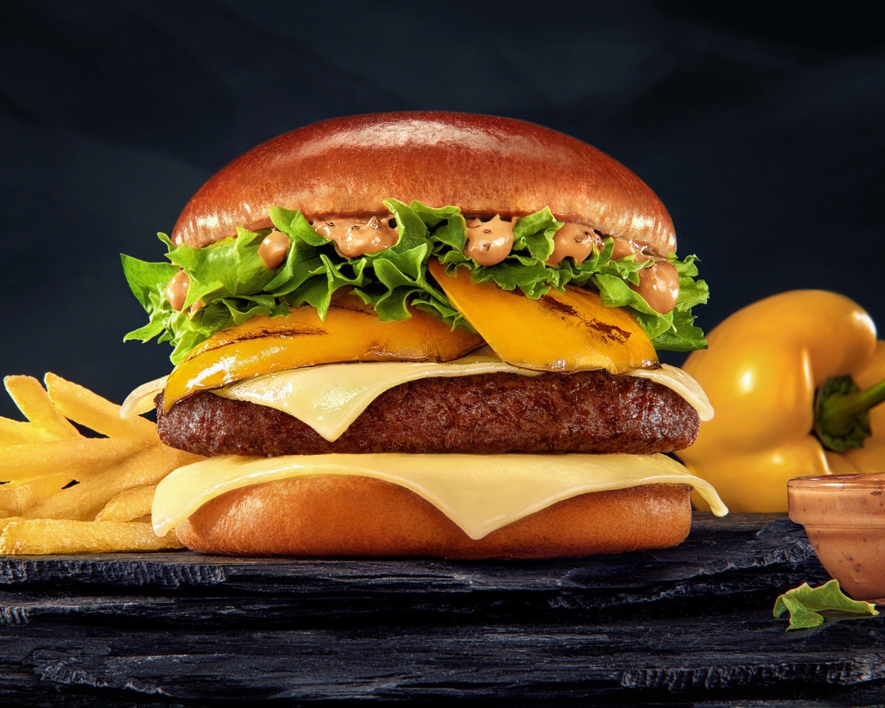 Аппетитный гамбургер с картофелем фри, болгарским перцем и соусом