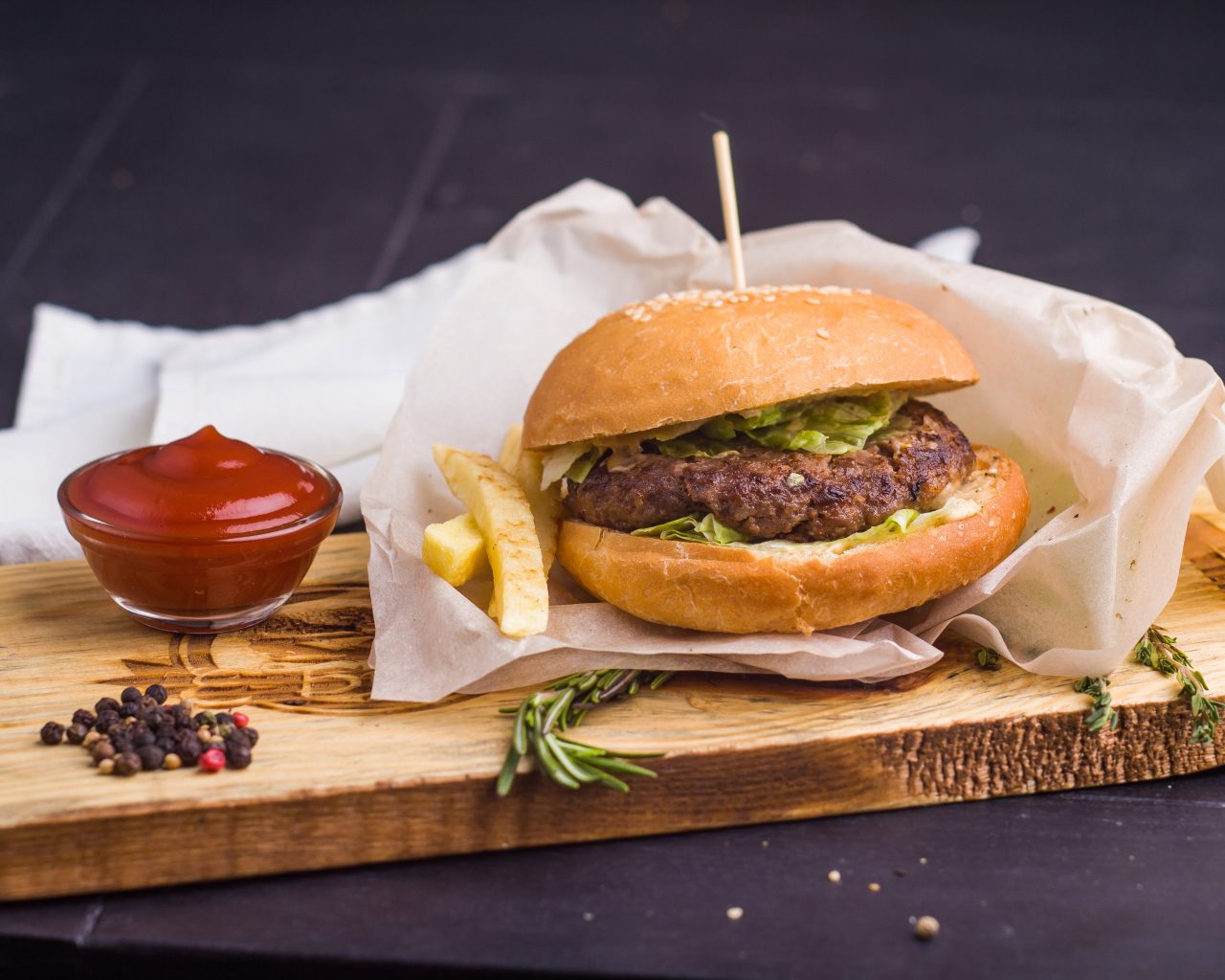 Аппетитный гамбургер с картофелем фри и кетчупом на столе