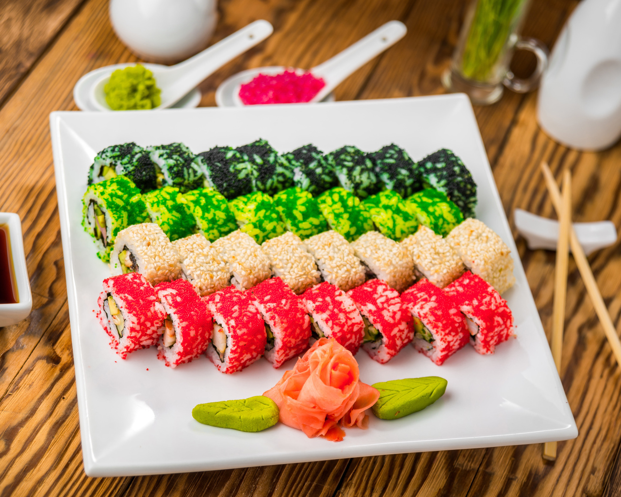 Аппетитные роллы с имбирем и соусом васаби на белой тарелке 