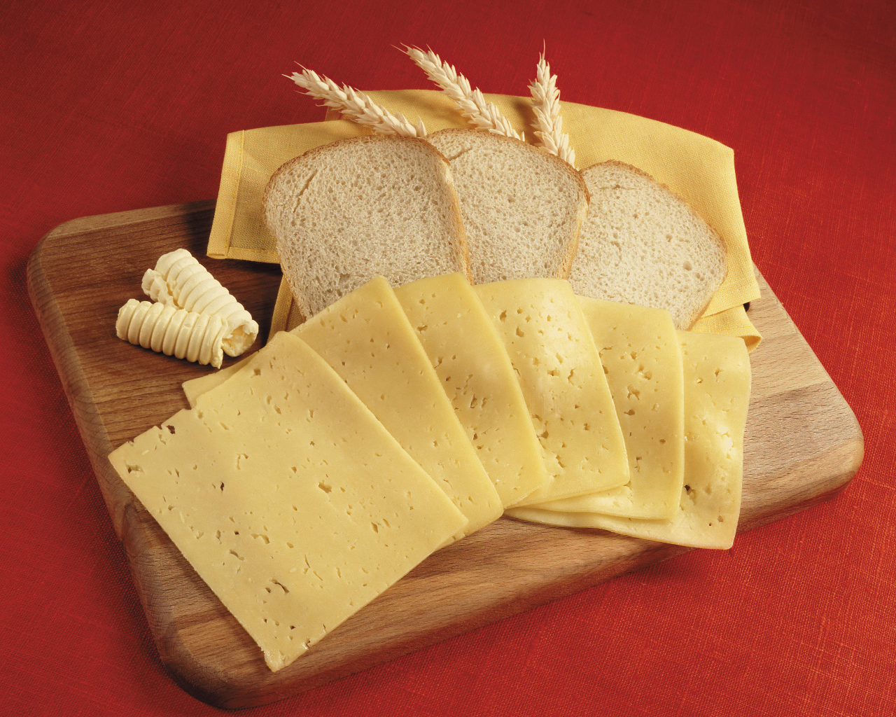 Хлеб с кусками сыра на разделочной доске