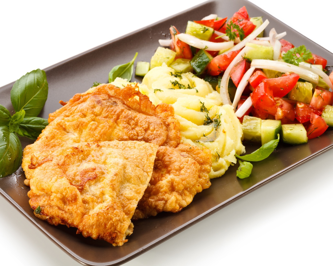 Отбивные с пюре и овощным салатом на тарелке