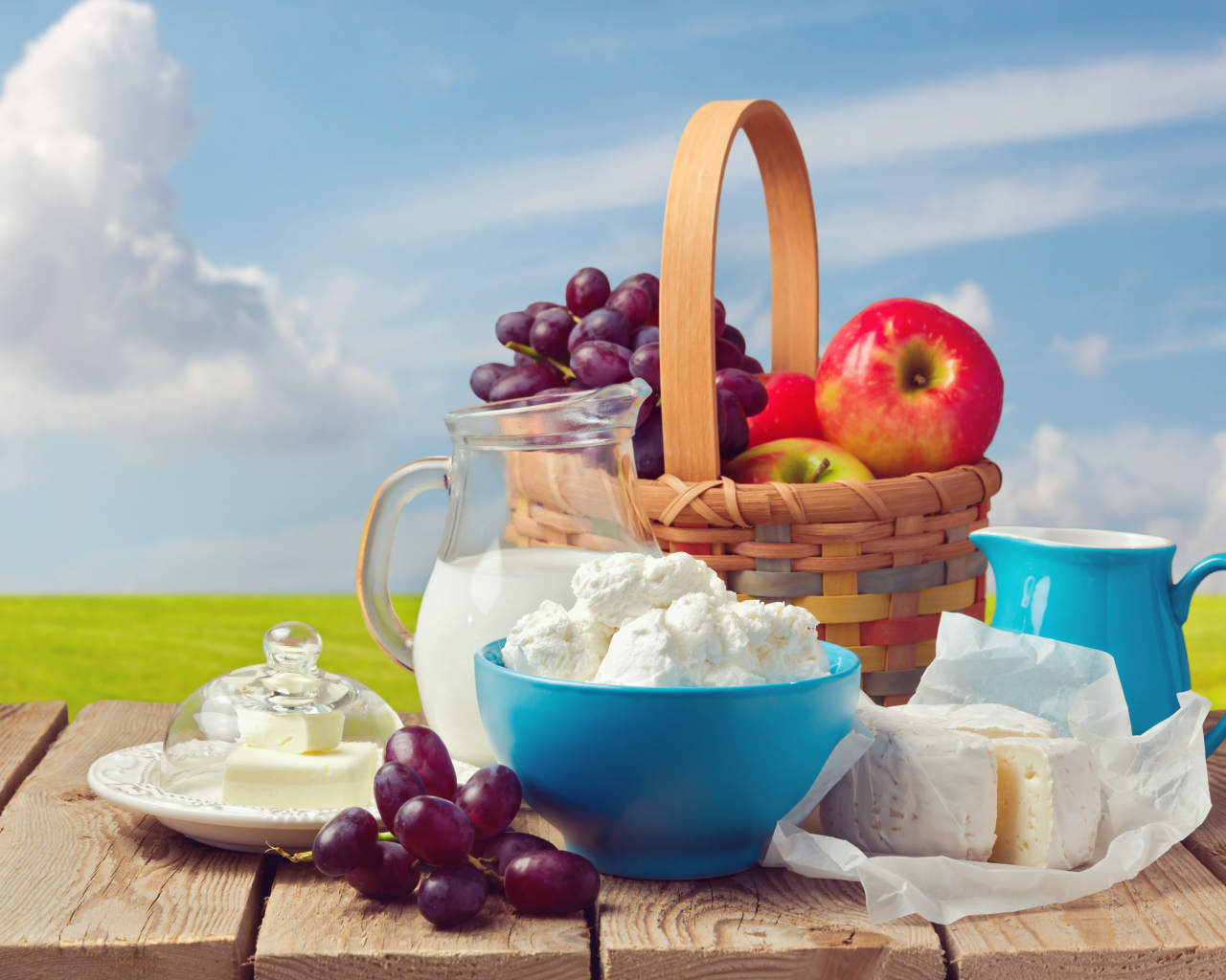 Творог с молоком на столе с виноградом и яблоками 