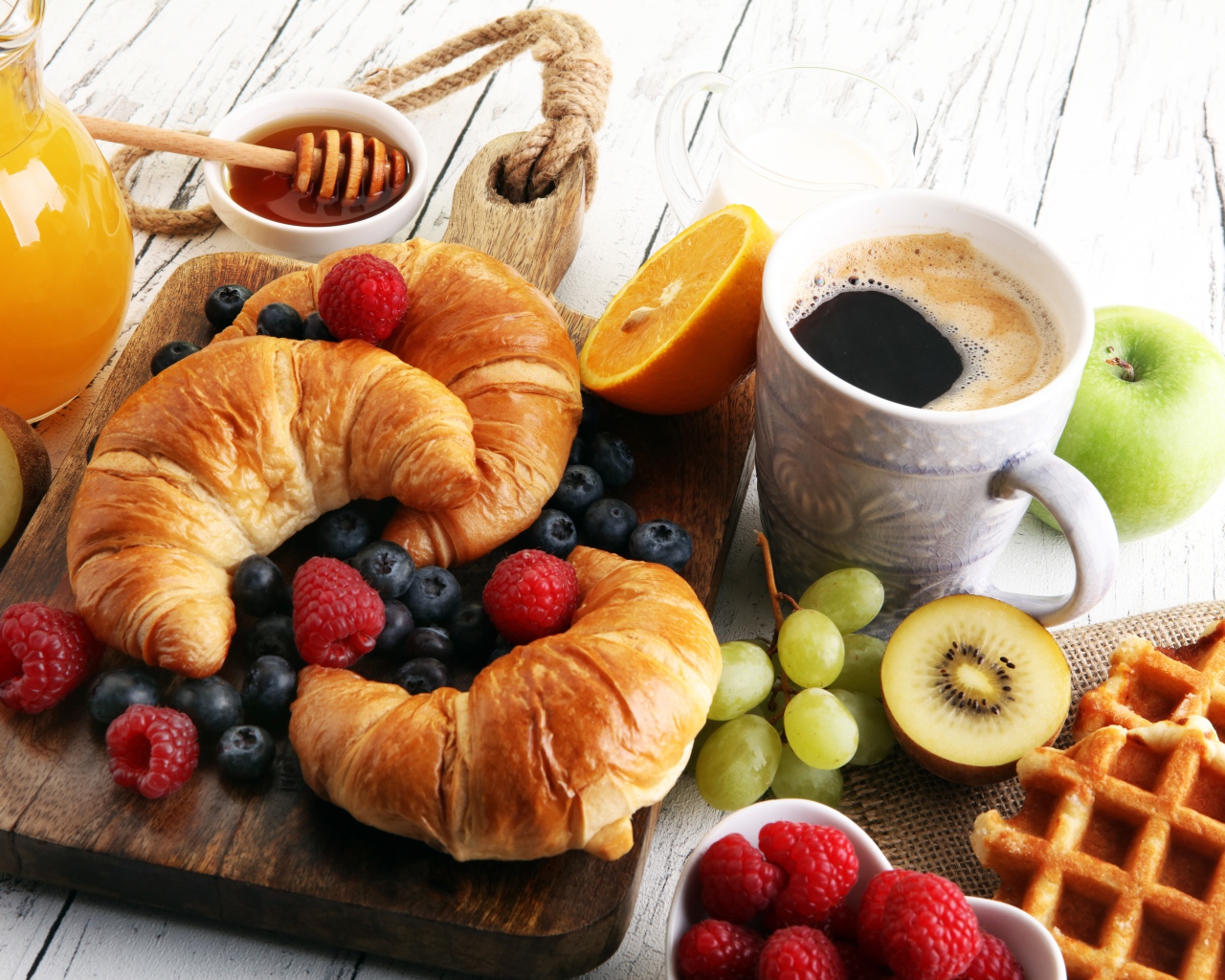 Круассаны с ягодами, на столе с кофе, медом и вафлями