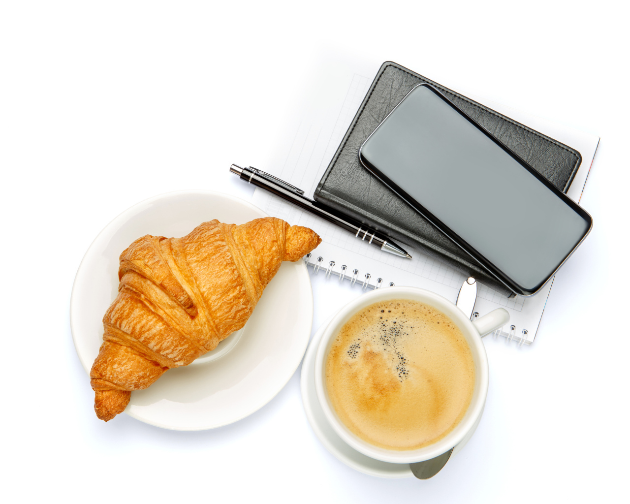 Чашка кофе, круассан, блонтон и смартфон на белом 