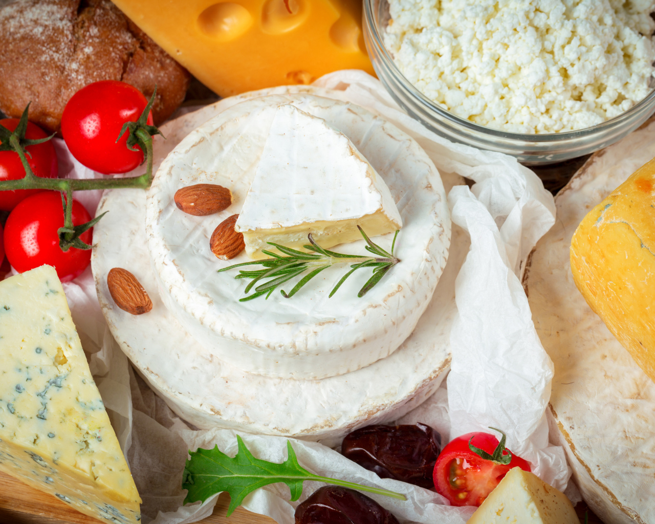 Разные виды сыра на столе с помидорами 