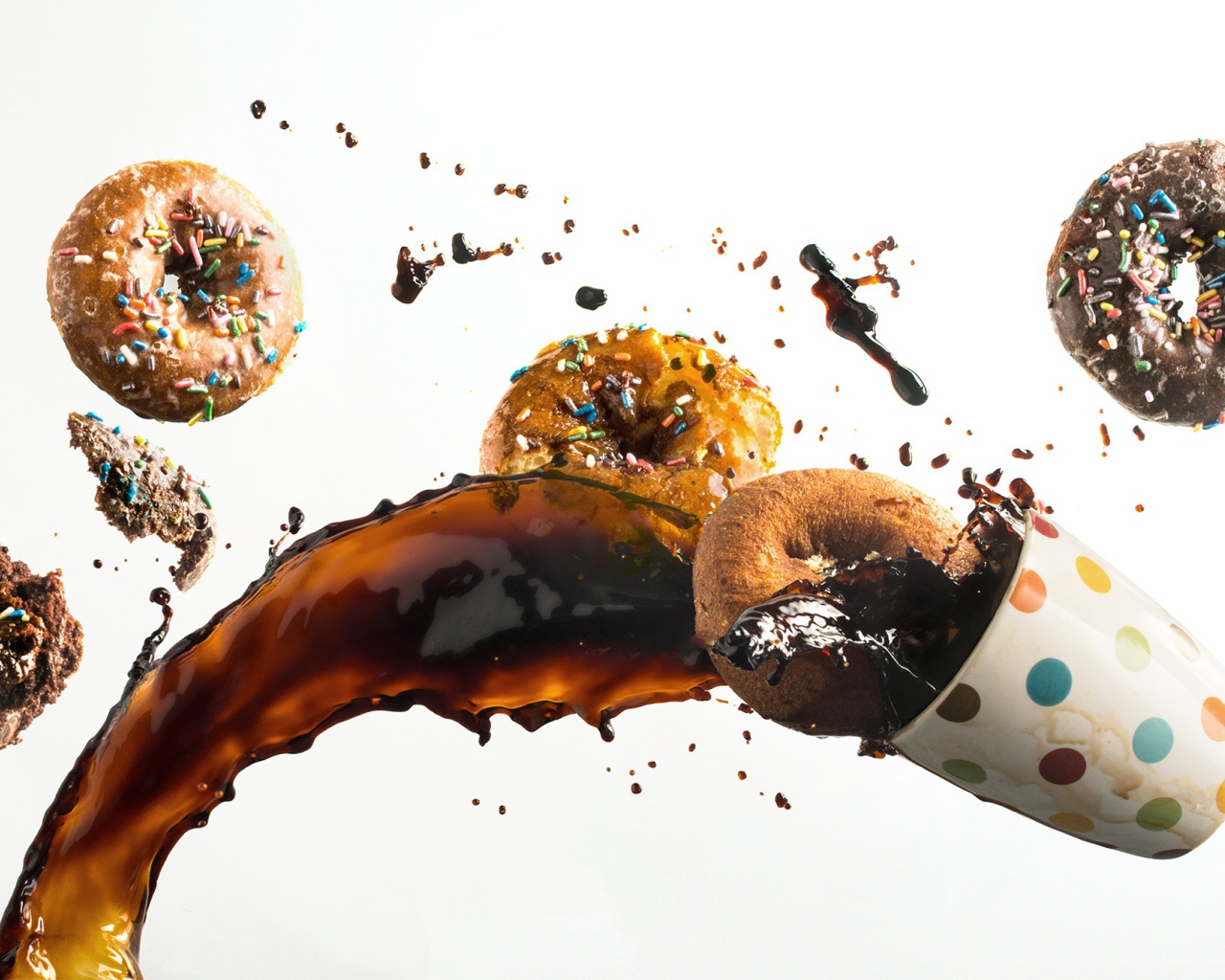 Пончики с чашкой кофе на белом фоне