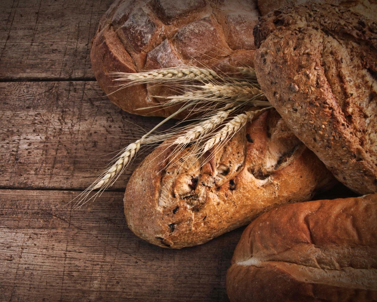 Свежий хлеб на столе с колосьями пшеницы