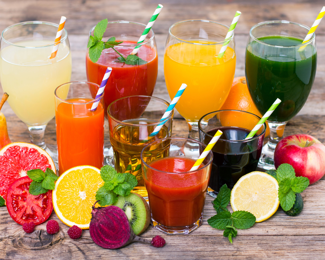 Свежевыжатые соки на столе с овощами и фруктами