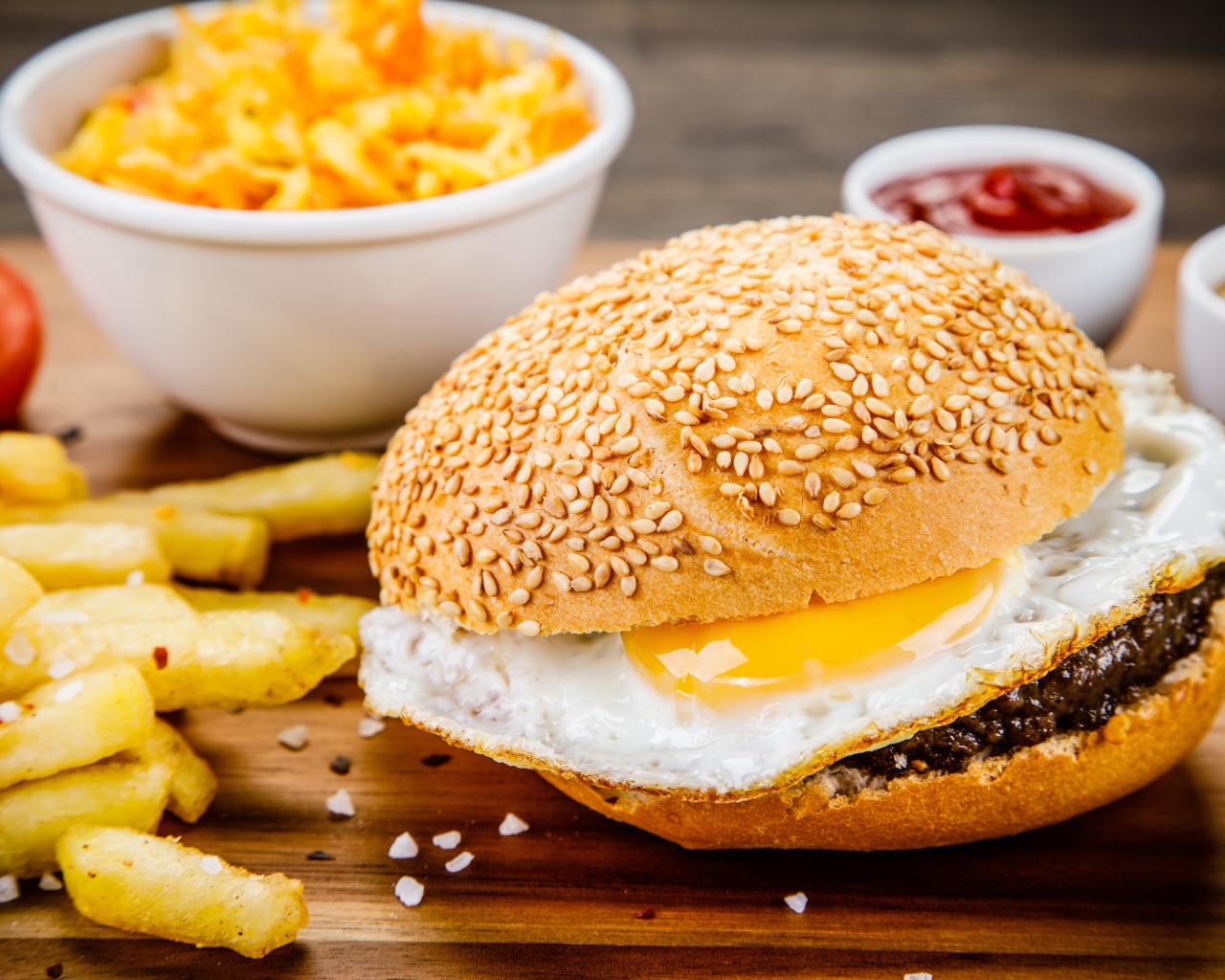 Гамбургер с яичницей на столе с картофелем фри и соусом