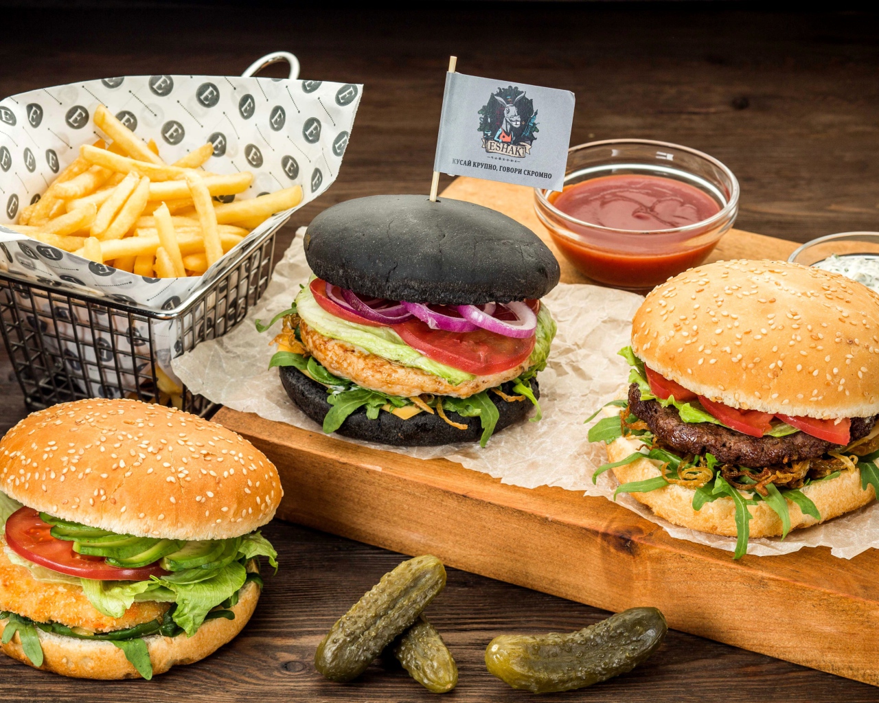 Гамбургеры с картофелем фри и солеными огурцами на столе 