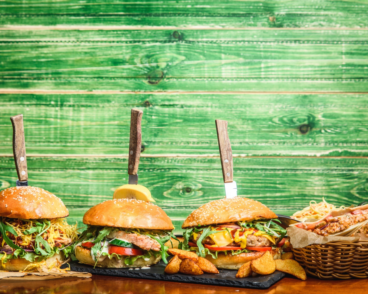 Гамбургеры с ножами на деревянном фоне