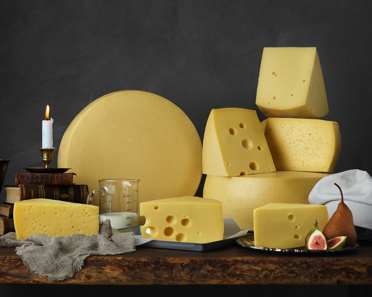 Твердый сыр на столе с книгами 