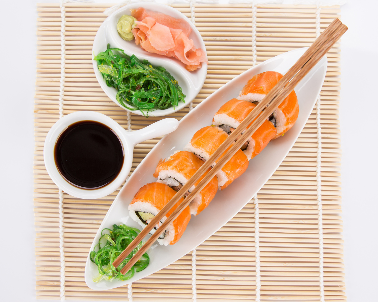 Японские суши на столе с соевым соусом и имбирем с салатом