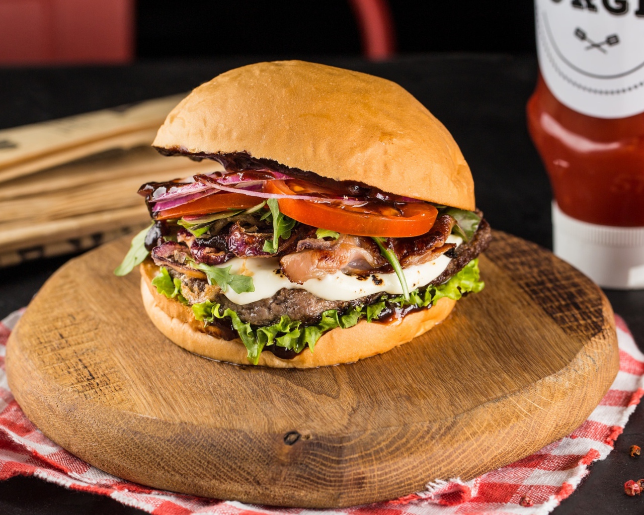 Большой аппетитный гамбургер на деревянной доске 