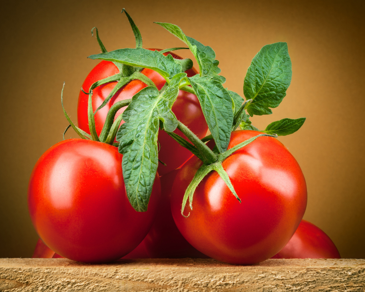 Крупные спелые красные томаты с зелеными листьями 
