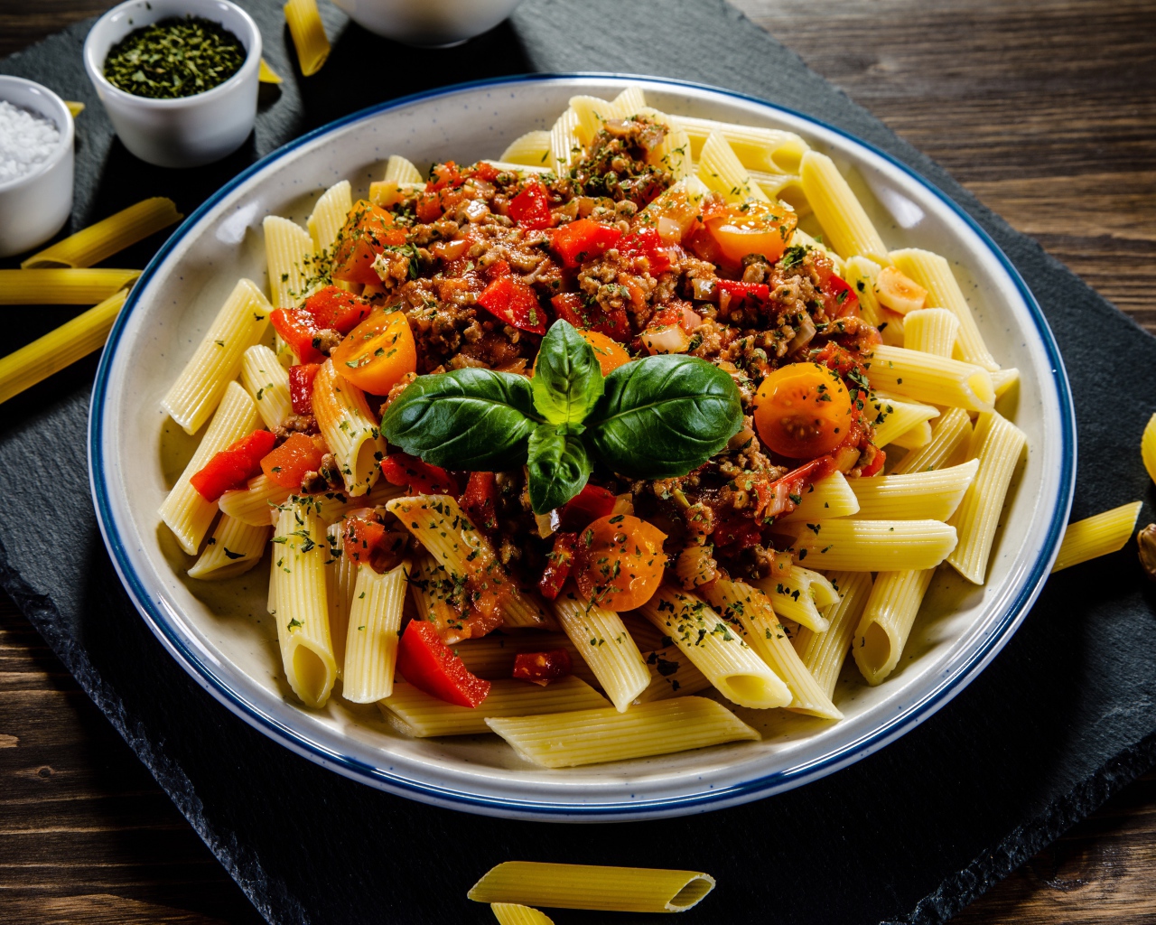 Макароны с фаршем и помидорами на столе