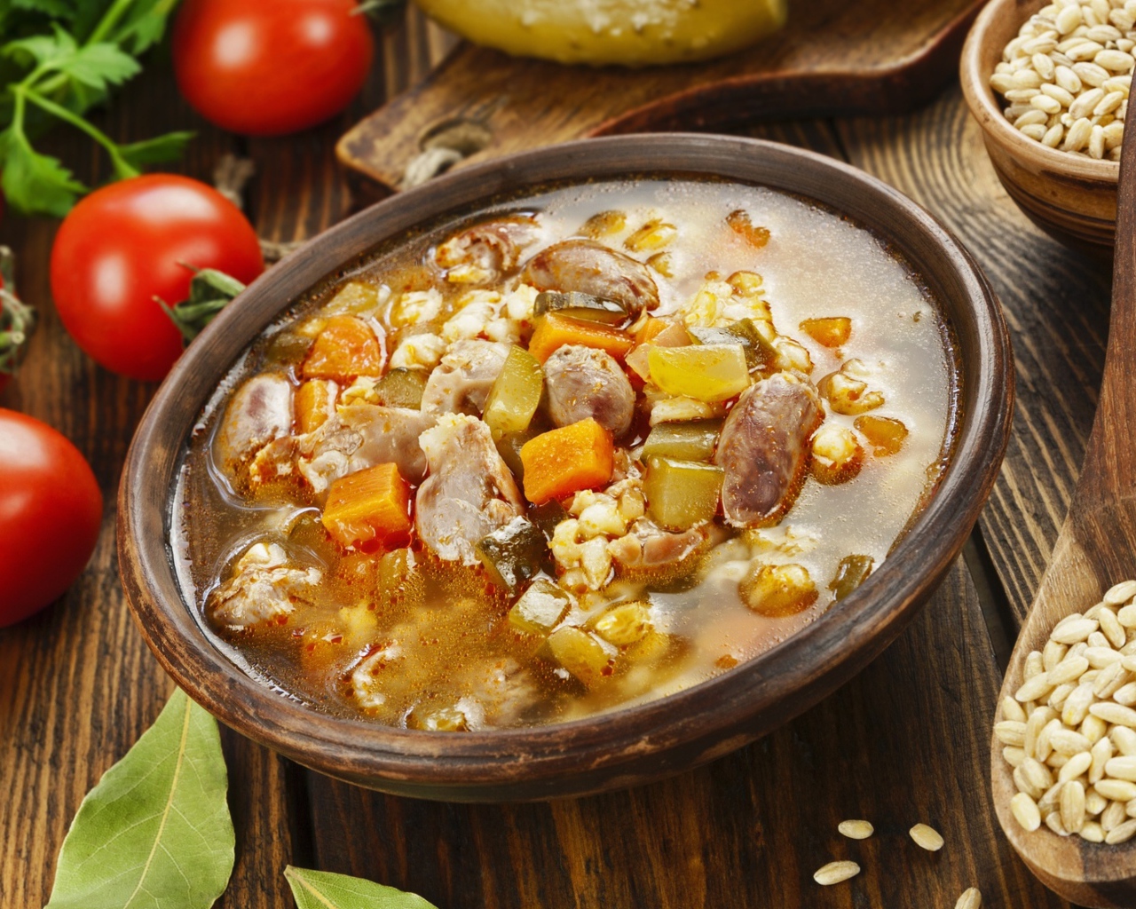 Перловый суп с сердечками на столе с помидорами 