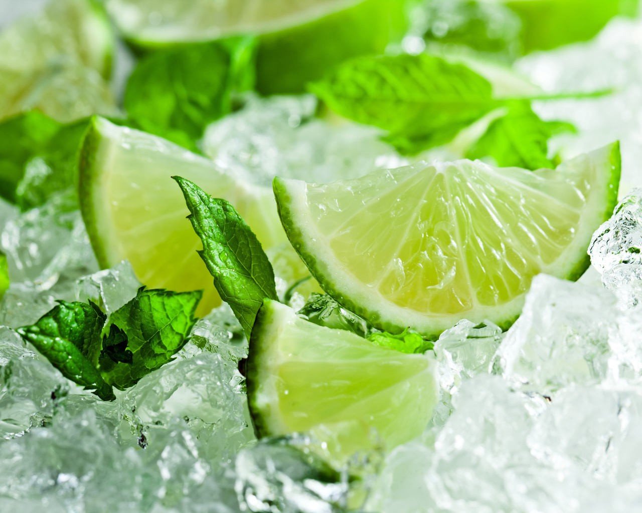 Кусочки свежего лайма с листьями мяты лежат на льду