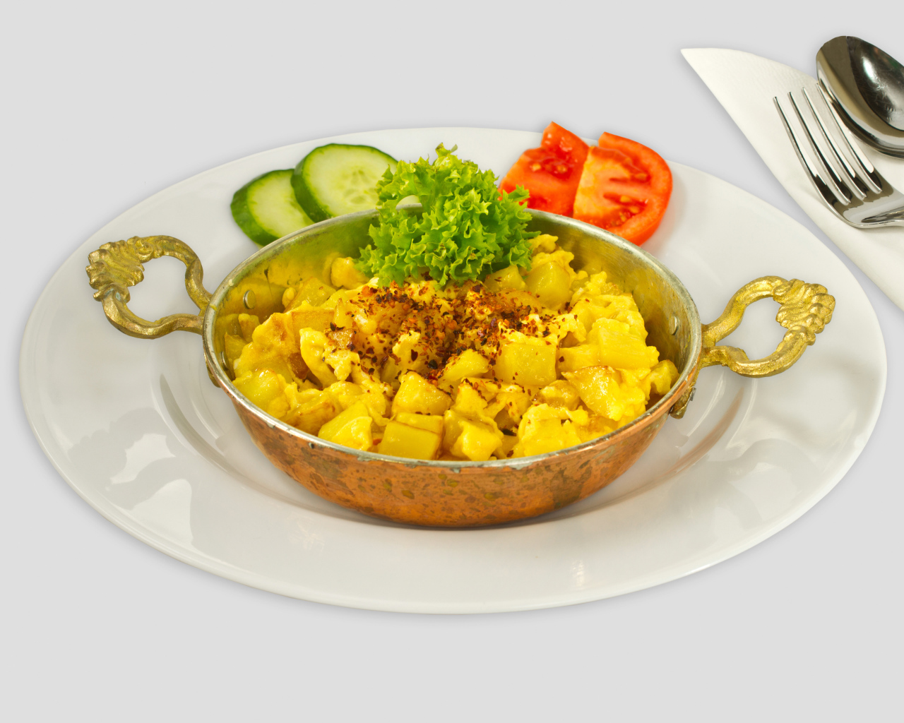 Картофель с овощами на белой тарелке