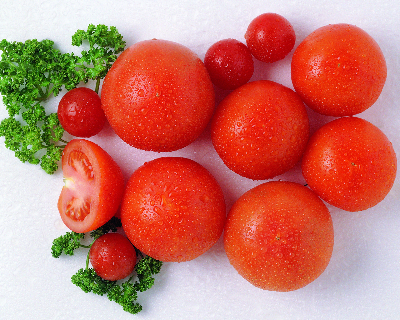 Спелые красные помидоры с зеленью петрушки в каплях воды