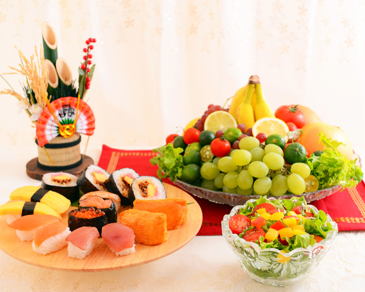 Роллы на столе с овощным салатом и фруктами 