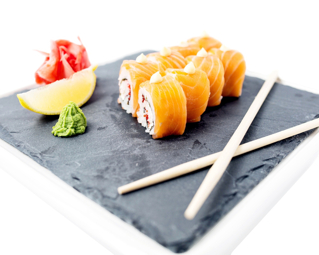 Роллы с красной рыбой на тарелке с палочками