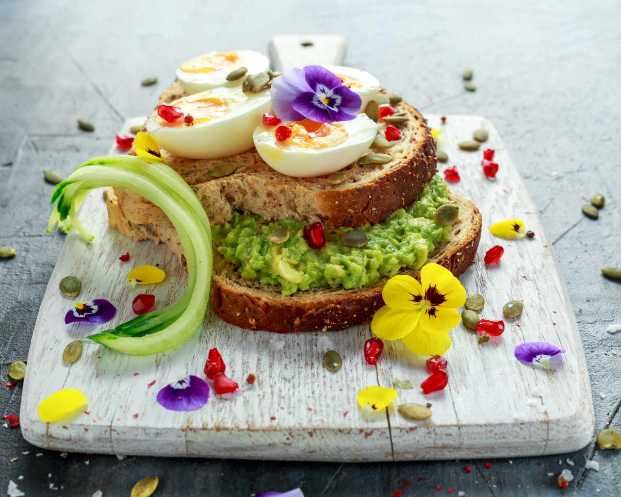 Сендвич с яйцом и цветами на доске