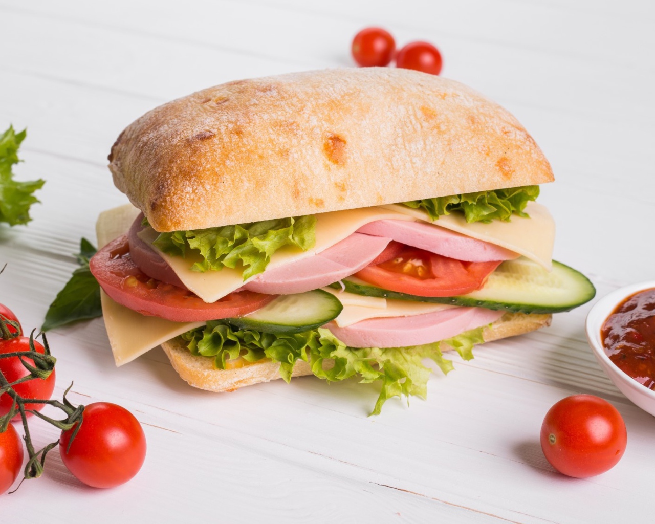 Сендвич с соусом и помидорами на столе 