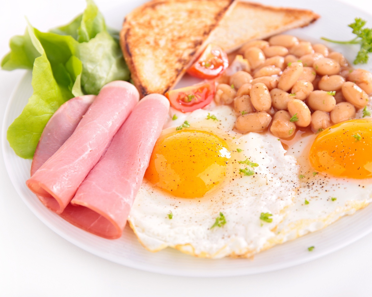 Яичница с беконом, гренками, фасолью и листьями салата на завтрак