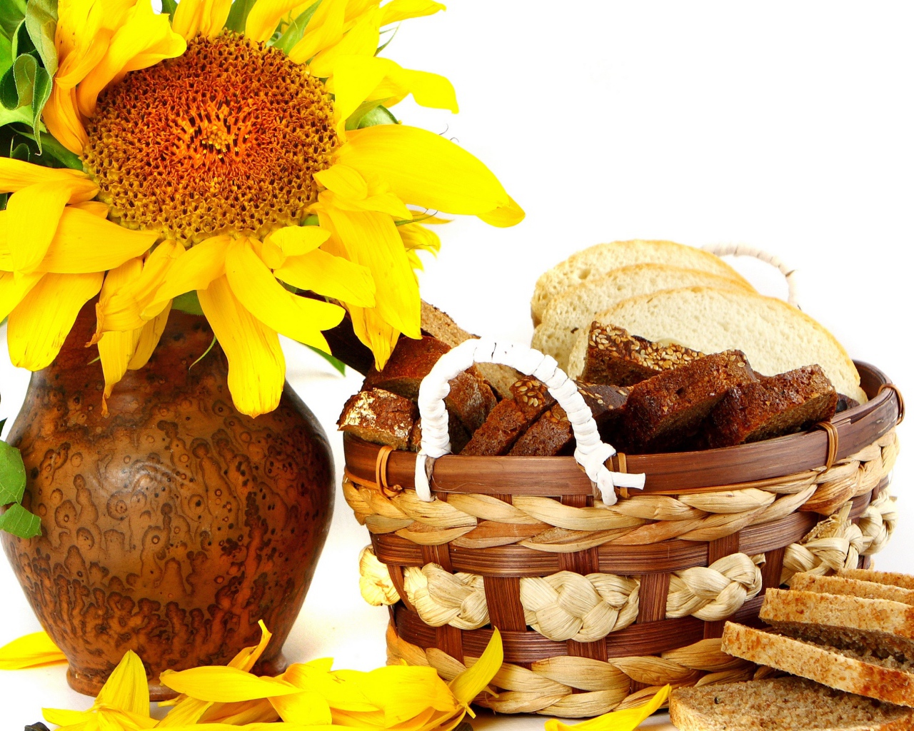 Цветок подсолнуха в кувшине на столе с корзиной с хлебом на белом фоне