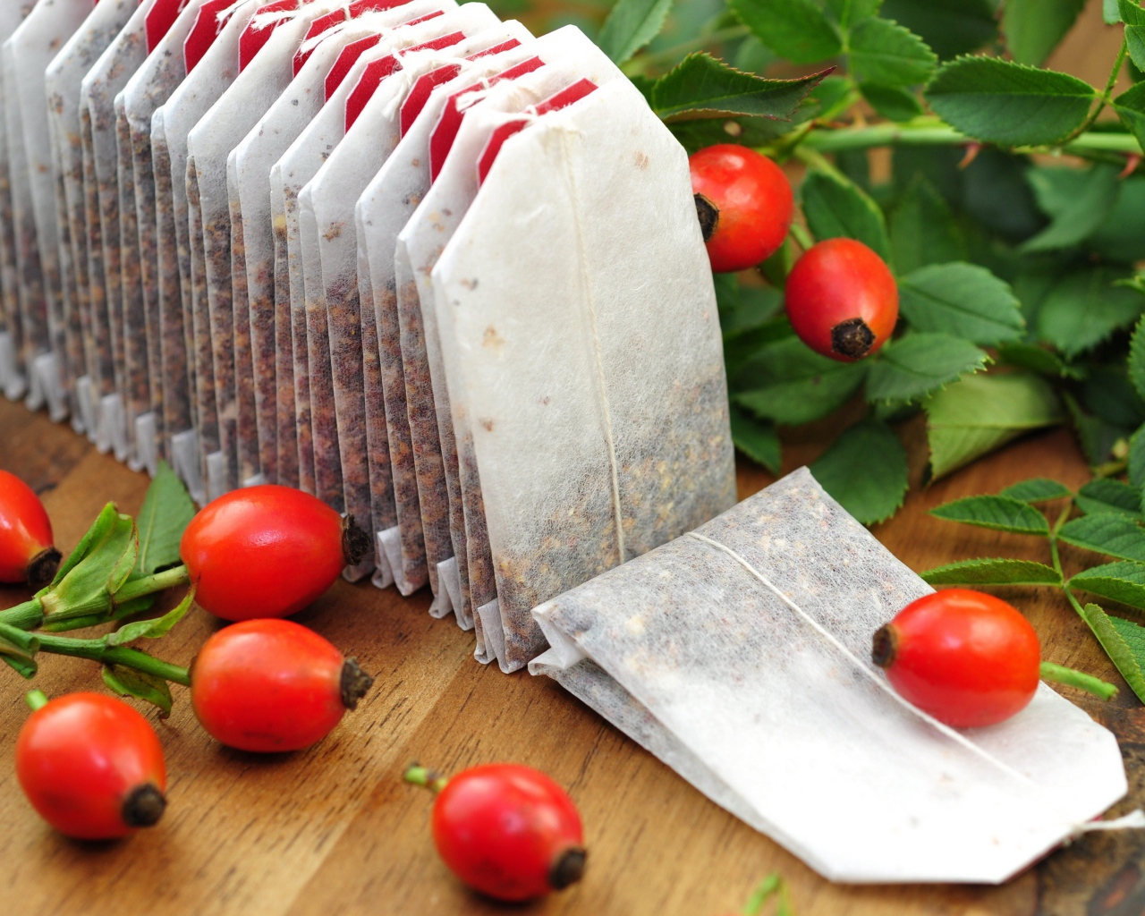 Чай в пакетиках на столе с ягодами шиповника 