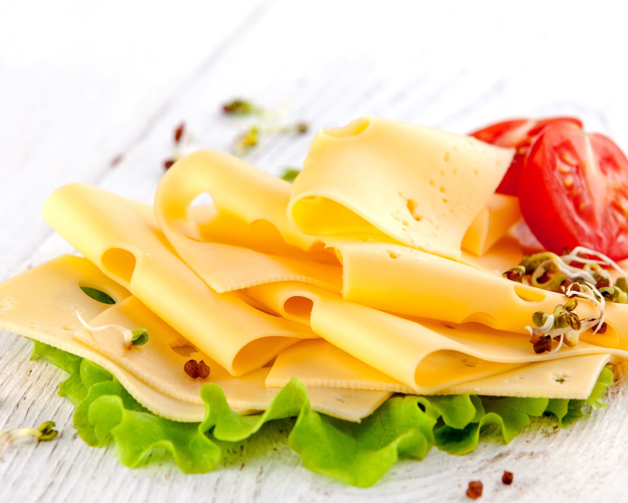 Тонко нарезанный сыр с листом салата и помидором