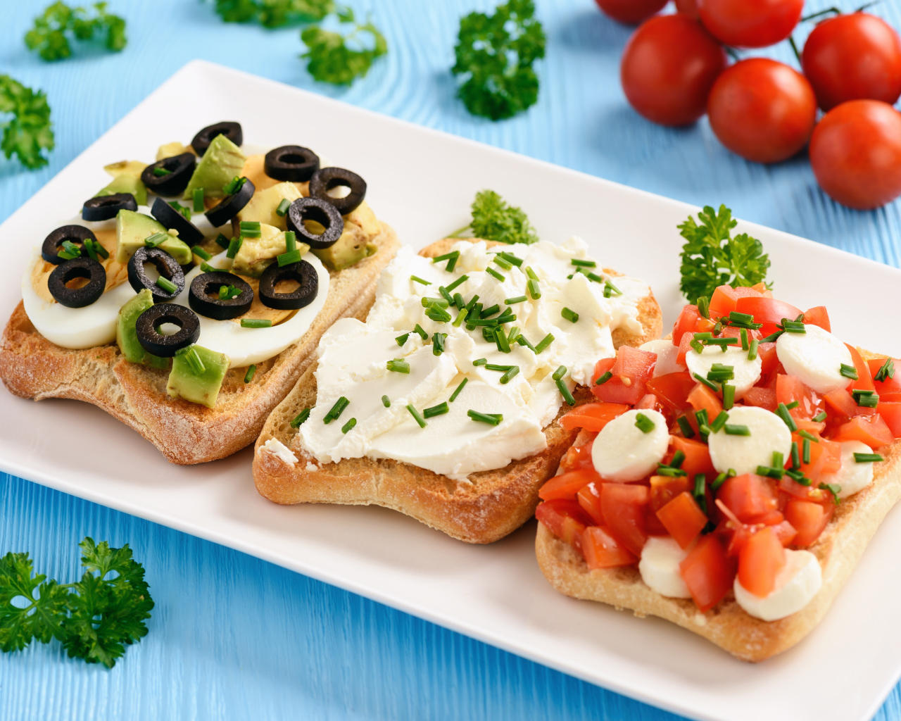 Три аппетитных бутерброда на столе с помидорами и петрушкой