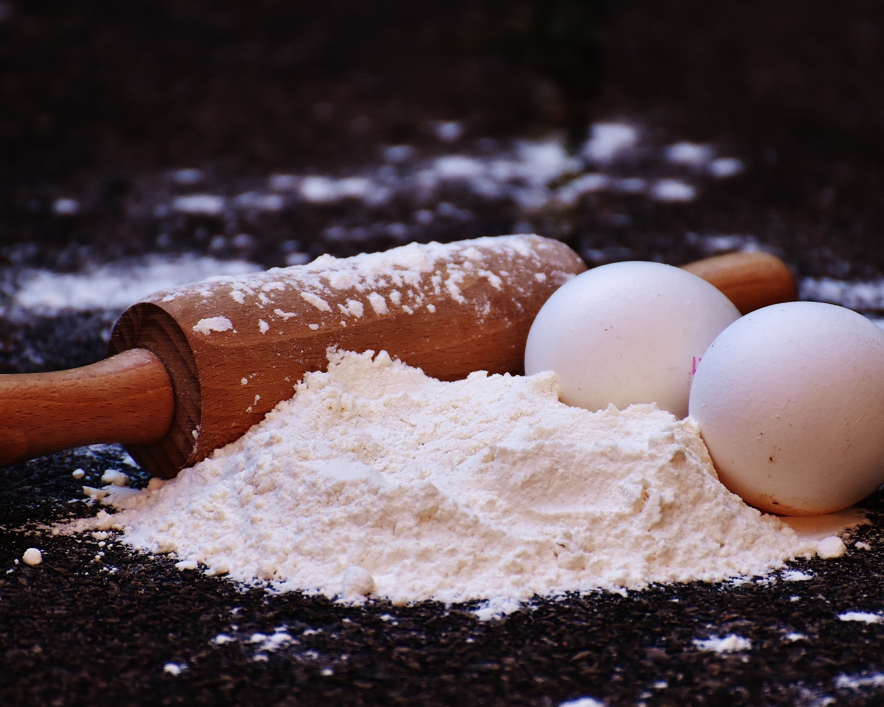 Два яйца, мука и скалка на столе