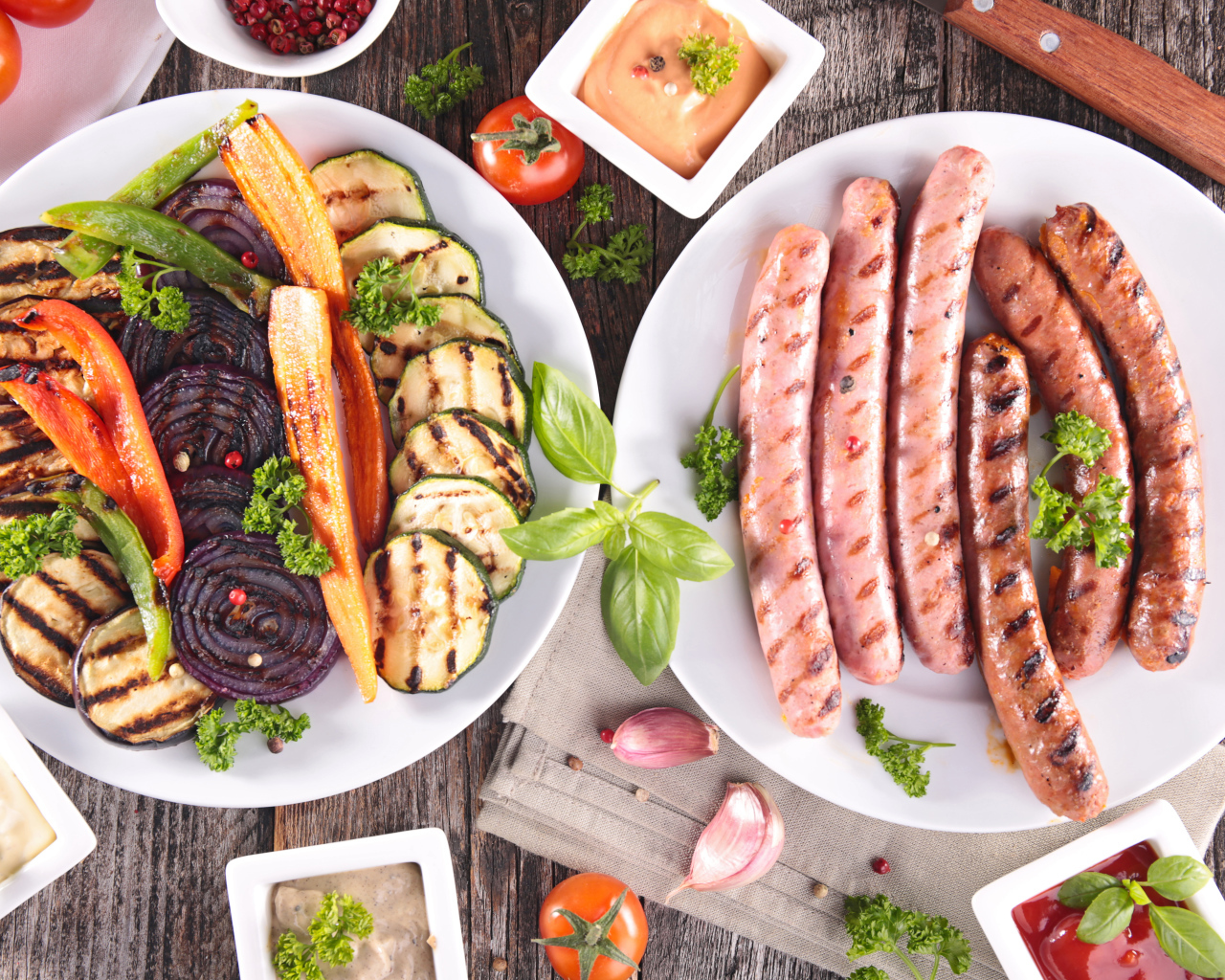 Овощи и сосиски гриль на столе с соусом