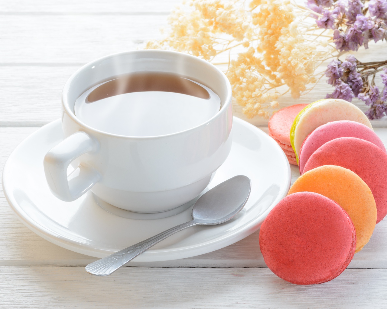 Белая чашка чая с макарунами