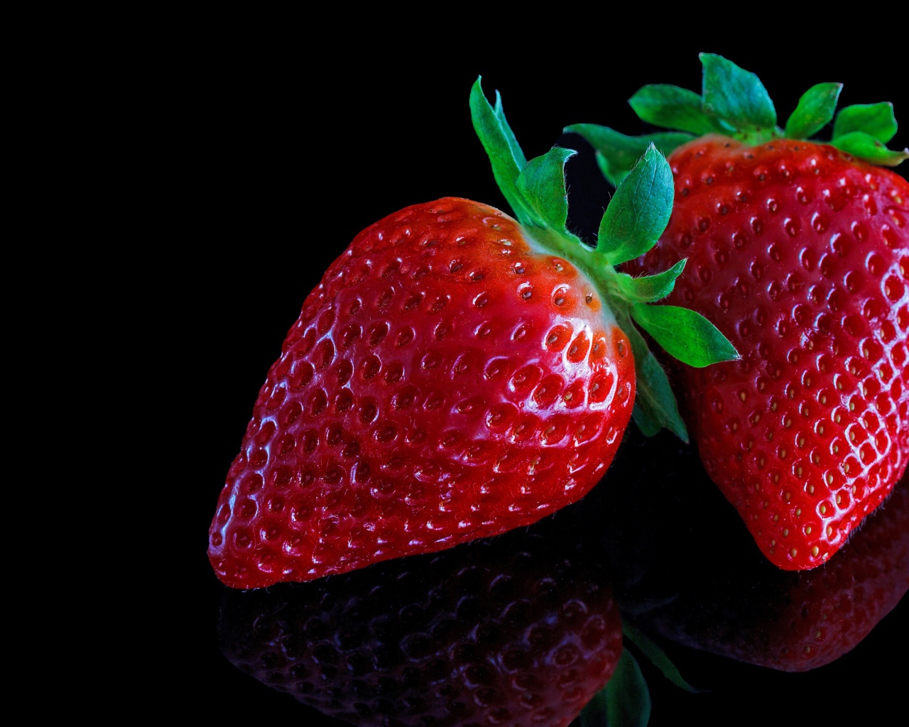 Красивая крупная красная клубника на черном  фоне