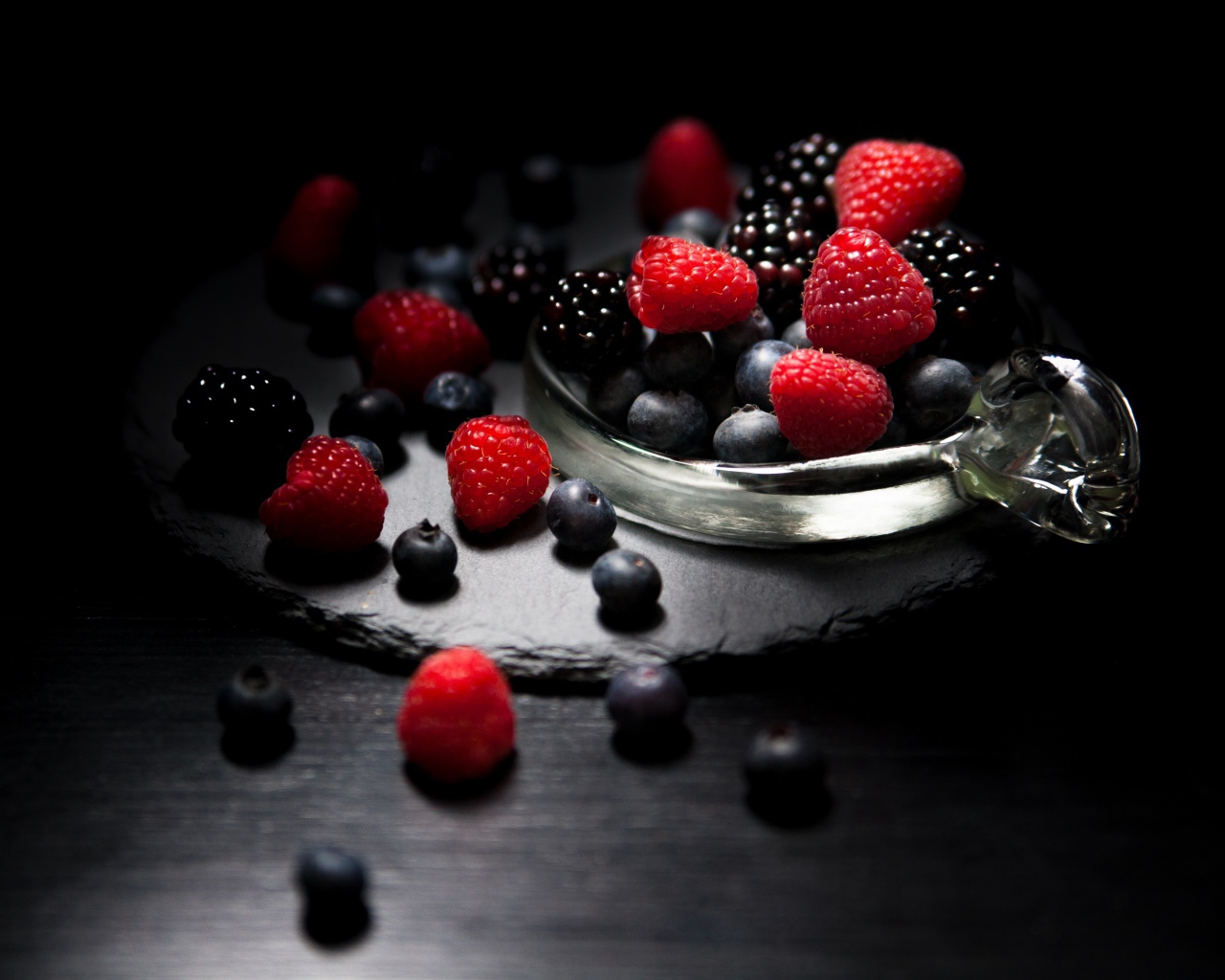 Ягоды черники, малины и ежевики на черном фоне