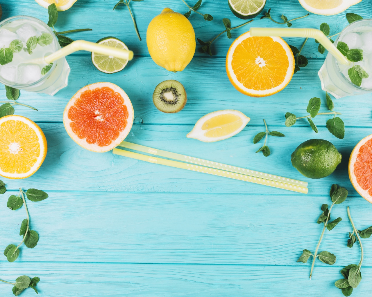 Цитрусовые фрукты на голубом столе с мятой и лимонадом