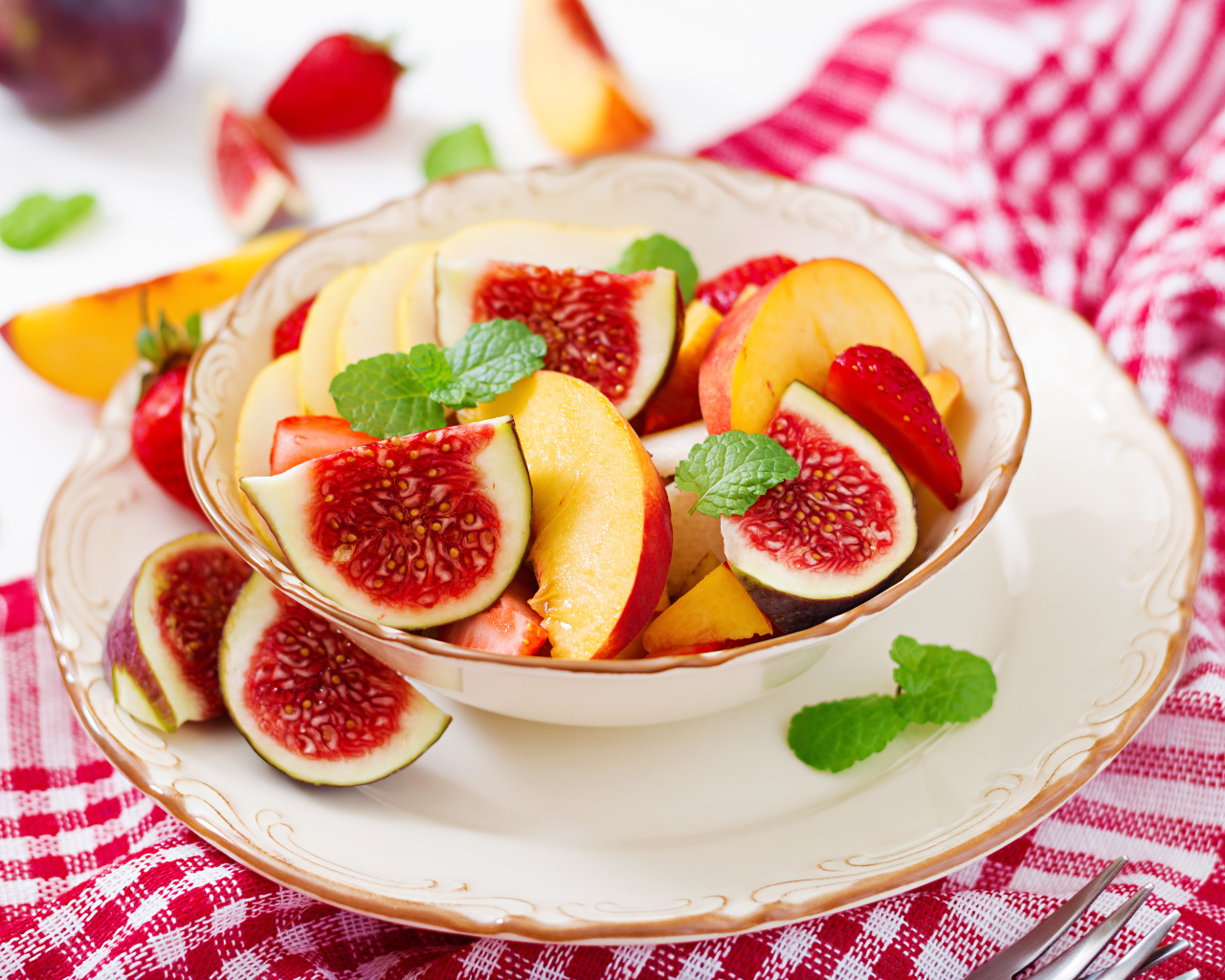 Свежие кусочки инжира и яблока в тарелке на столе