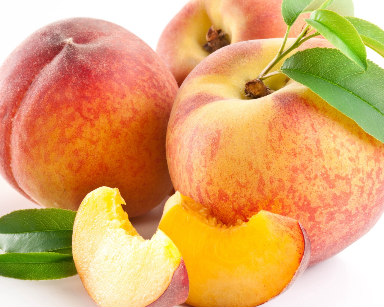 Крупные спелые сладкие персики на белом фоне