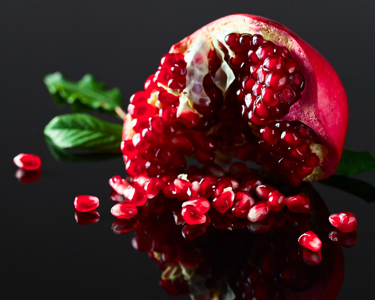 Чищенный гранат на сером фоне крупным планом