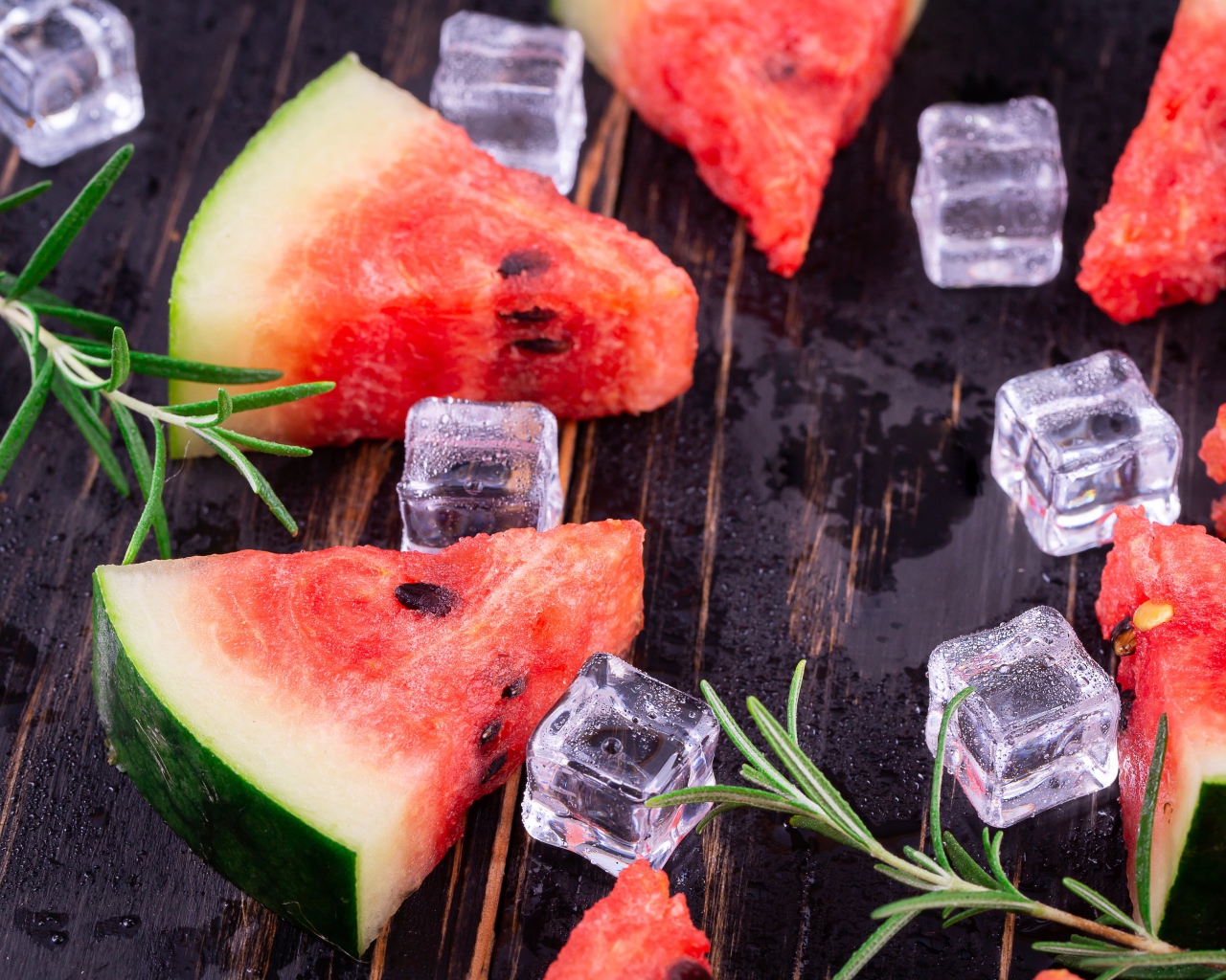Кусочки арбуза на столе со льдом и розмарином