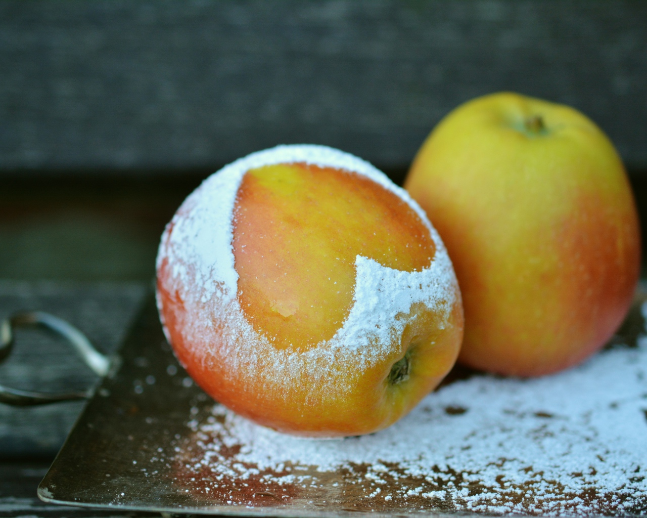 Спелое яблоко с сердцем из сахарной пудры на столе 