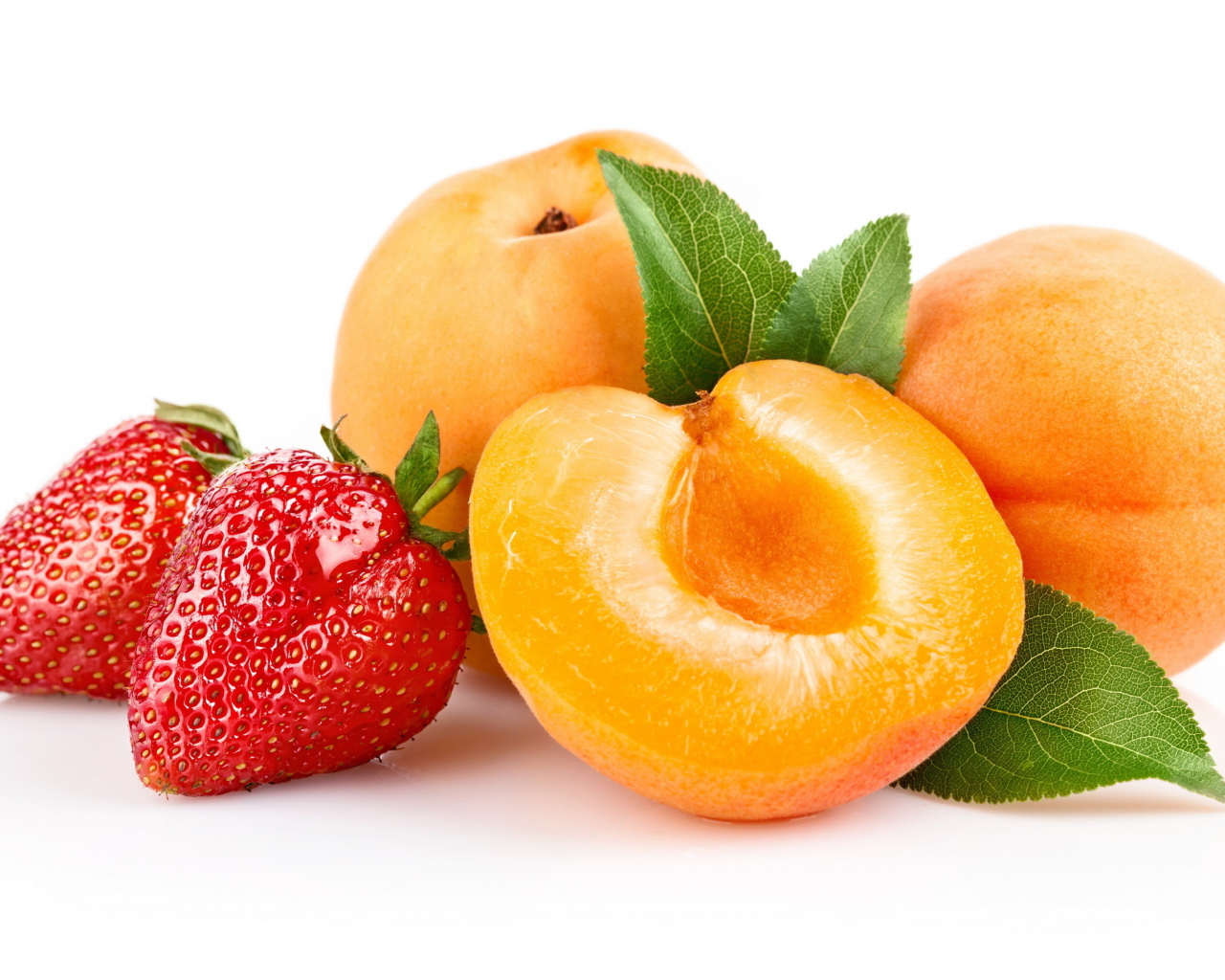 Спелые абрикосы с ягодами клубники на белом фоне